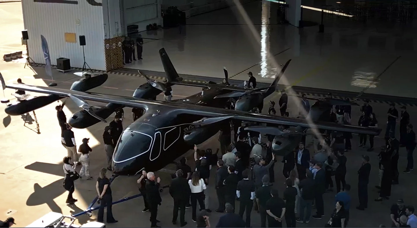 The prototype Eve Air Mobility has no room for passengers yet, but the paint job gives you a rough idea of what the cockpit might look like. And with the people checking it out