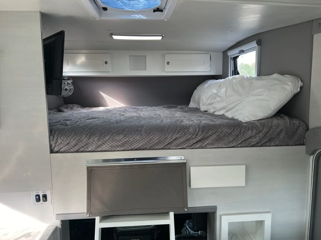 Tiger describes the alcove bed as a modified queen and includes a TV in the space