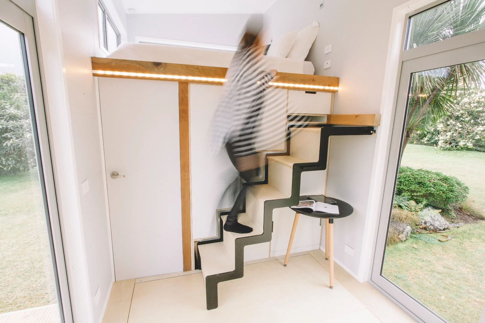 The Millennial Tiny House's retractable staircase in use