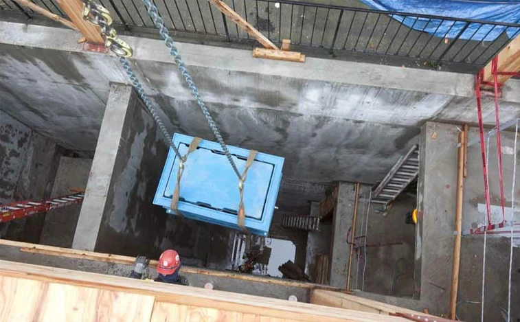 A composter is lowered into the basement, March 2012