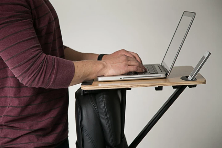 The StorkStand is simply strapped onto the back of an existing office chair