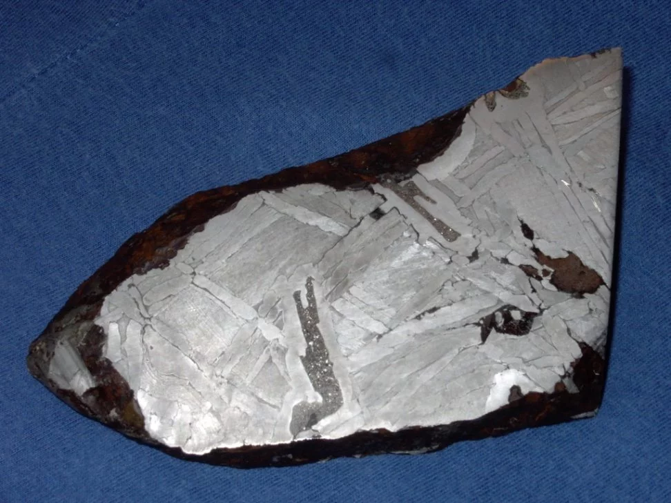 A 15 cm-wide fragment of the Seymchan iron-nickel meteorite found in Russia in 1967 – the long filament of dark grey material in the centre is the phosphorus-rich mineral schreibersite