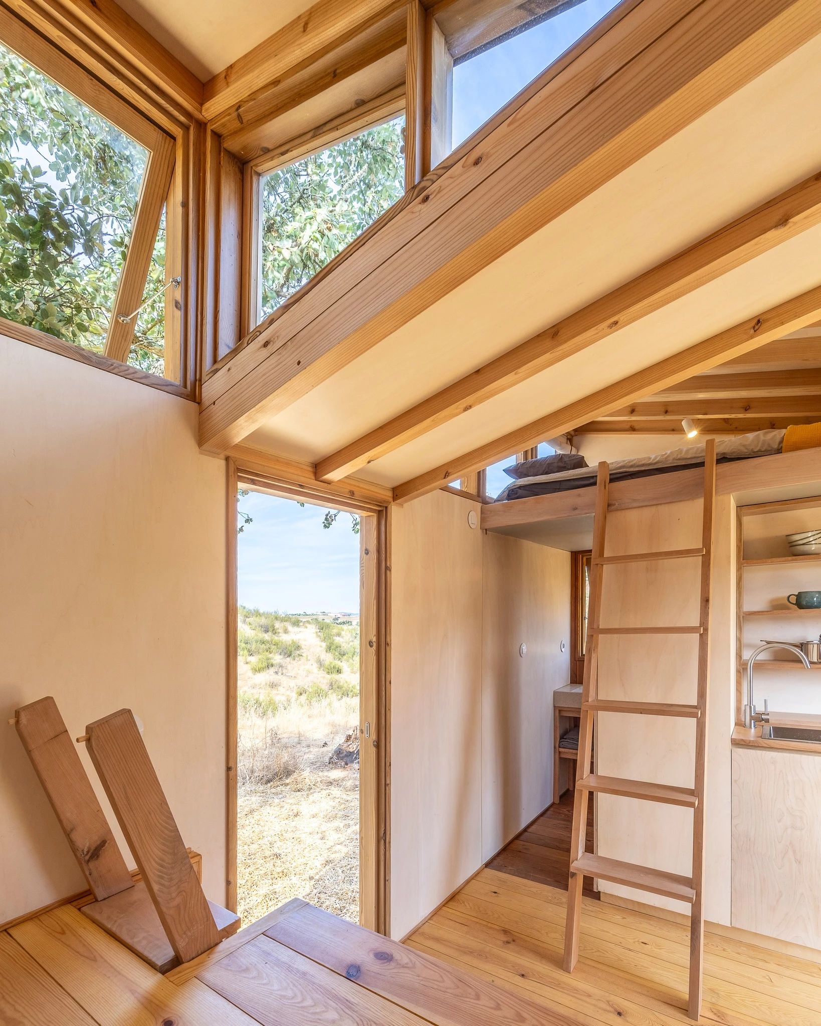 The Terra m3_Tiny House's bedroom is accessed by a removable wooden ladder