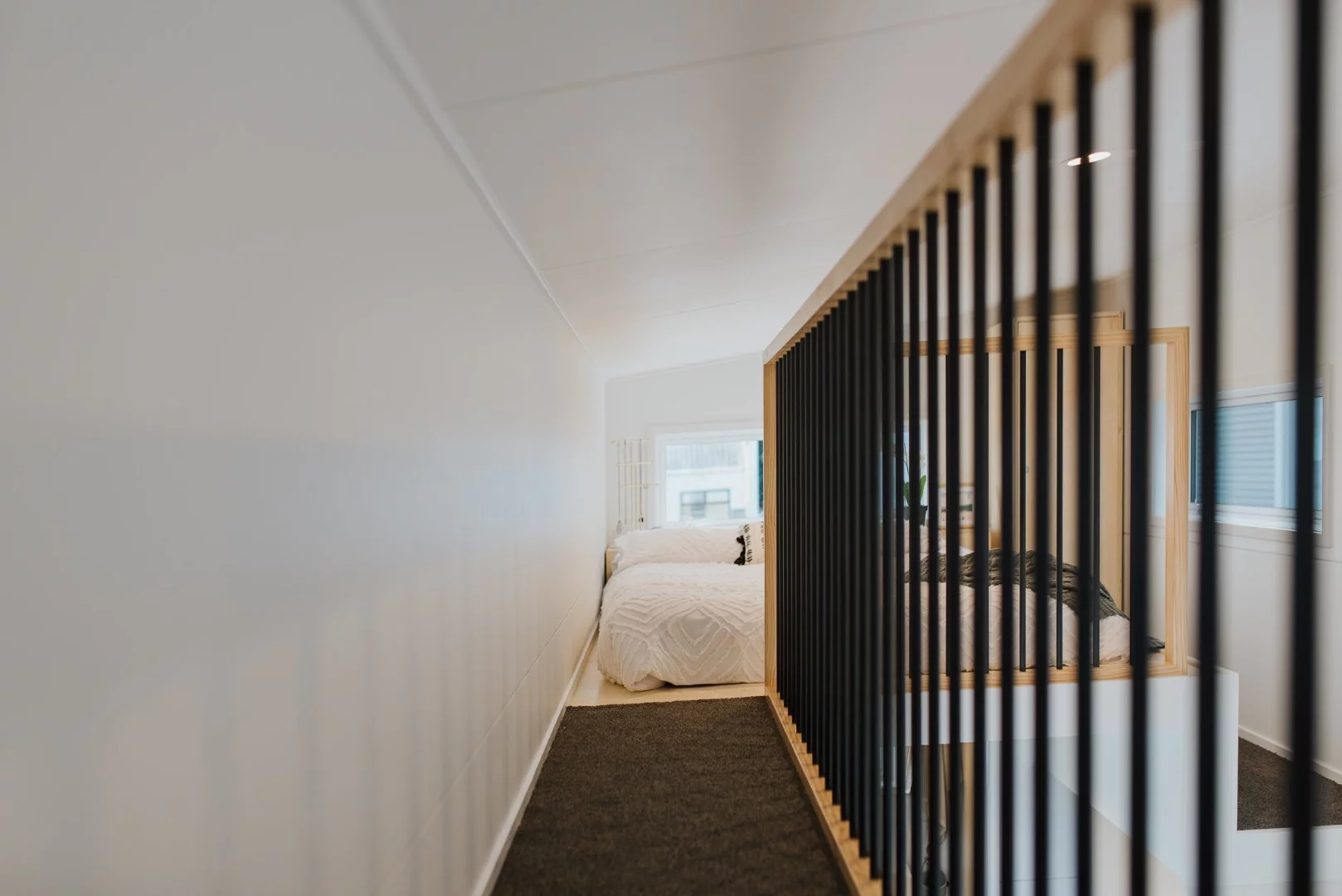 The Dance Tiny House's two lofts are joined by a catwalk with a safety barrier