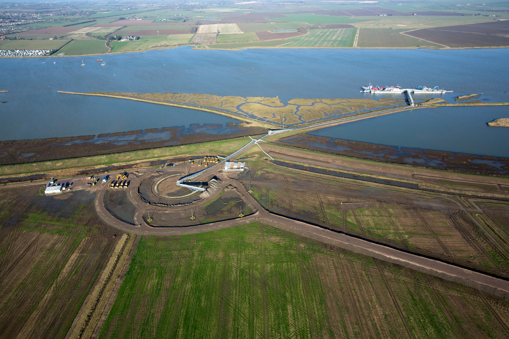 Earth is unloaded from a ship in the distance, transported along the conveyor system and deposited by the radial stacker