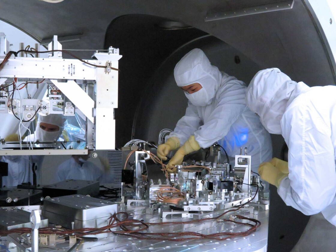 LIGO team members install new components that help reduce quantum noise, which could mask small gravitational wave signals