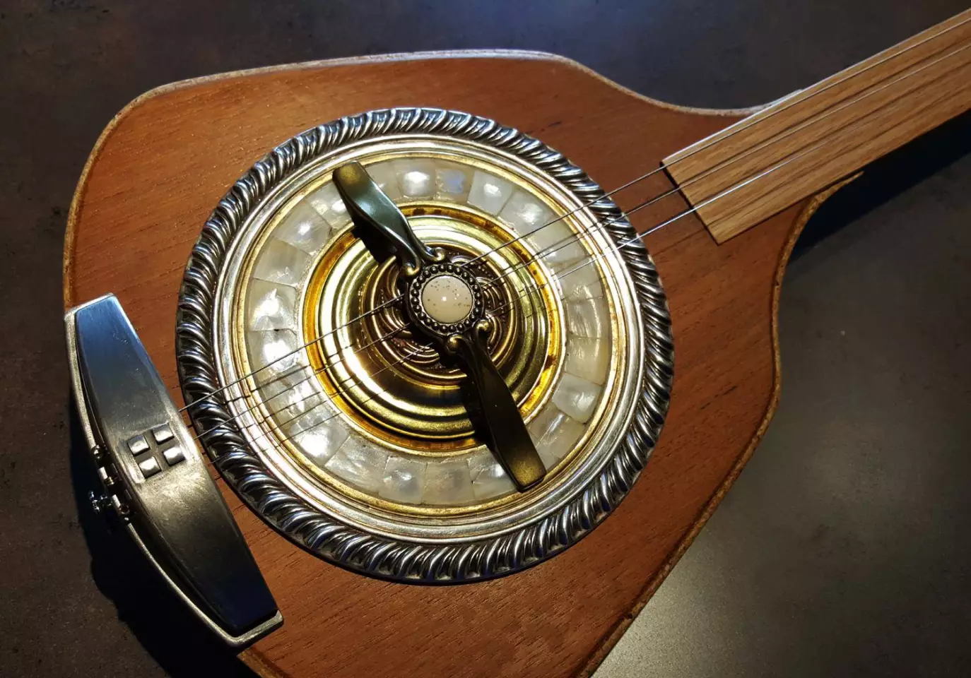 The Erin guitar's resonator is made from a silver serving bowl, a brass candle plate and some brass lighting components