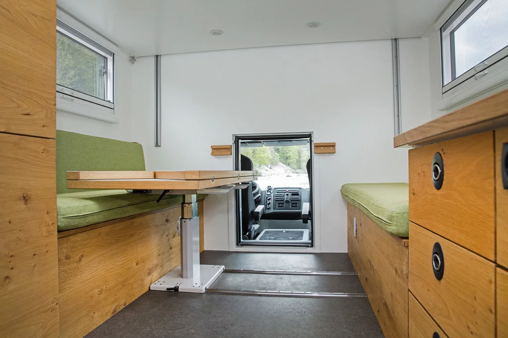 The available driver cab pass-through is located behind/below the dining table