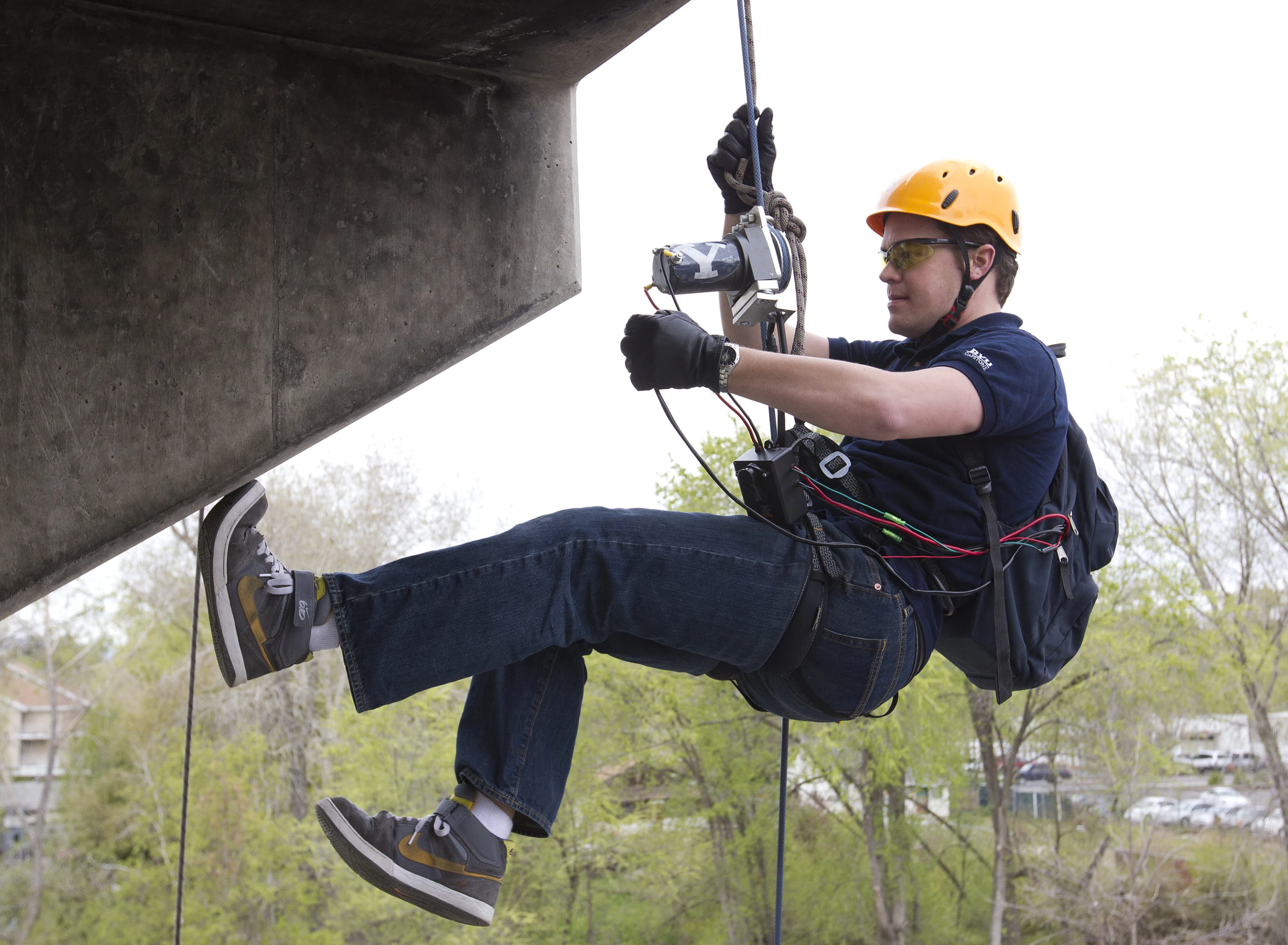 Engineering student Brady Morton uses the winch device to ascend a tower