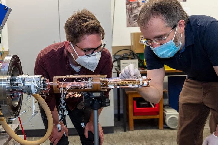 Researchers Matthew Bohman (left) and Christian Smorra (right) with the new two-trap cooling system