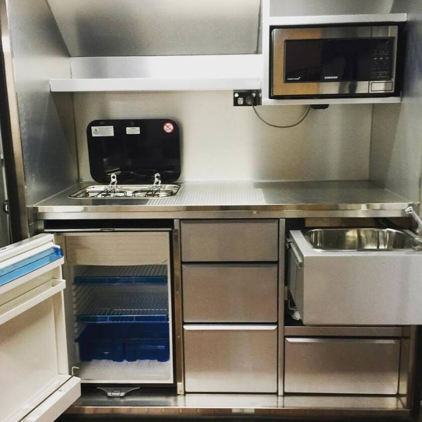 The deck-top kitchen is rather impressive, with its large worktop, slide-out sink and microwave