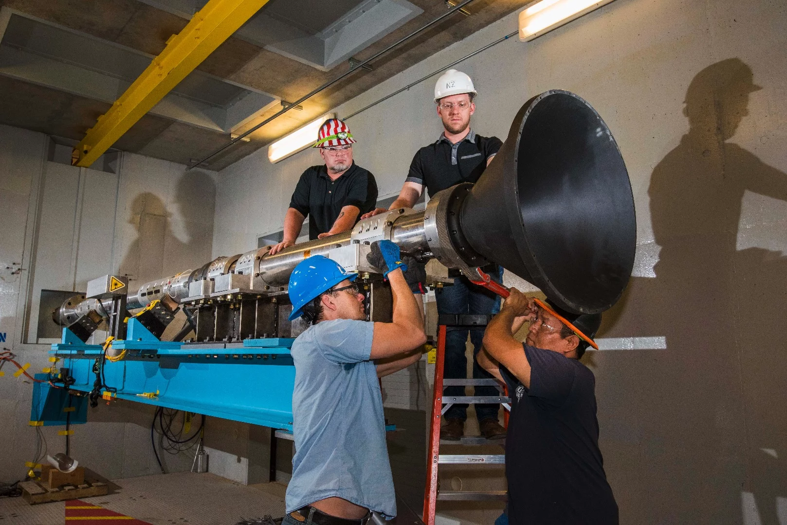 Sandia engineers attach a resonant cone to a modified Hopkinson bar known as a resonant beam, in preparation for an alternative pyroshock test