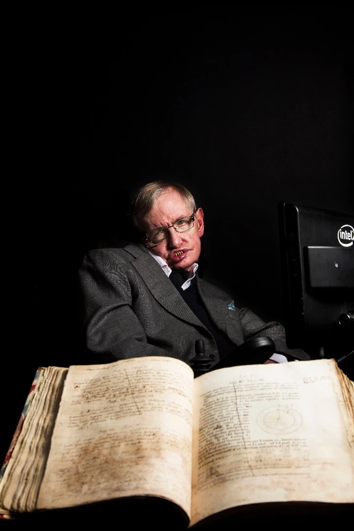 Stephen Hawking pictured with Isaac Newton's own annotated copy of Principia Mathematica