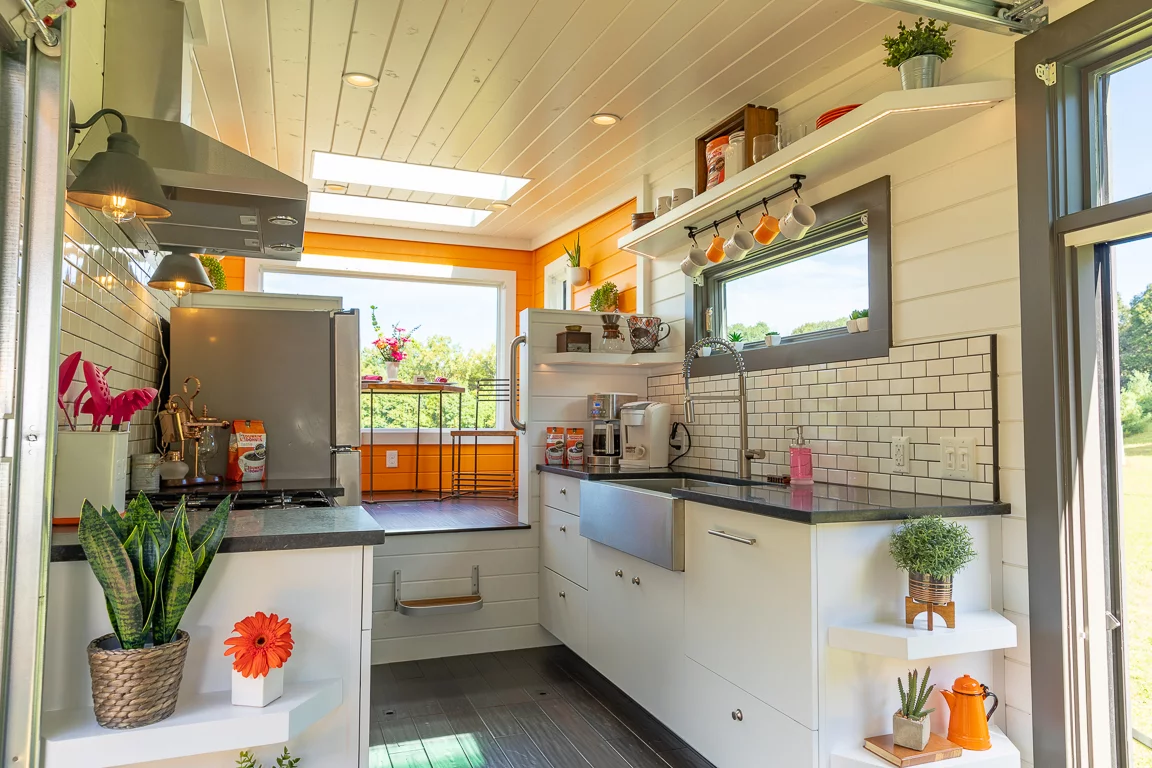 The Home That Runs on Dunkin's kitchen includes a full-size fridge, oven, and a small dishwasher, as well as a coffee machine