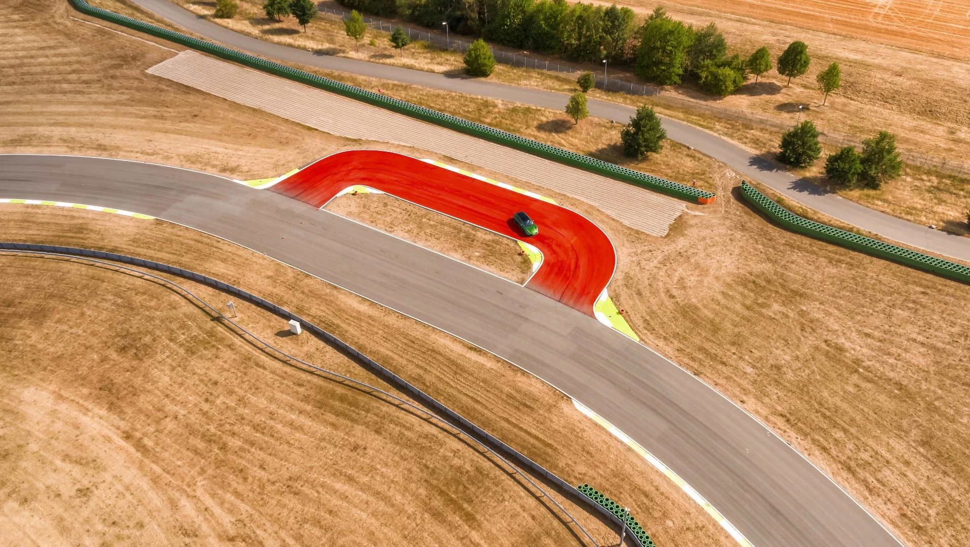 This is the famous "Bus Stop chicane" from the Circuit of Spa-Francorchamps in Belgium: The tight left-right-left combination demands courage and perfection. To master this bend, drivers must stay perfectly straight, then turn the car and accelerate out of the curbs under full load