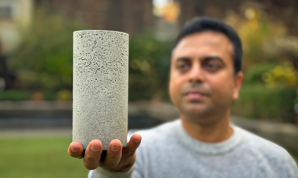 Dr. Chamila Gunasekara holds a sample of the low-carbon concrete
