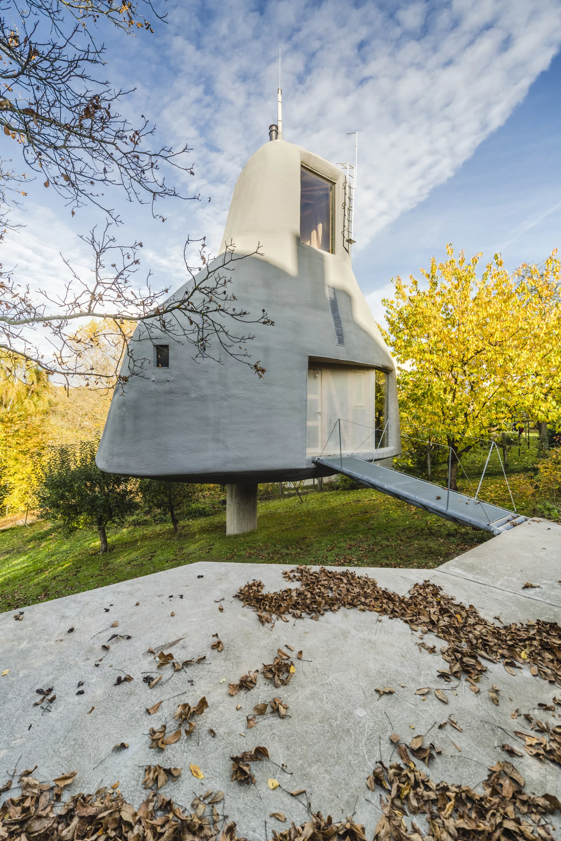 A fixed steel bridge leads from a platform to the House in the Orchard