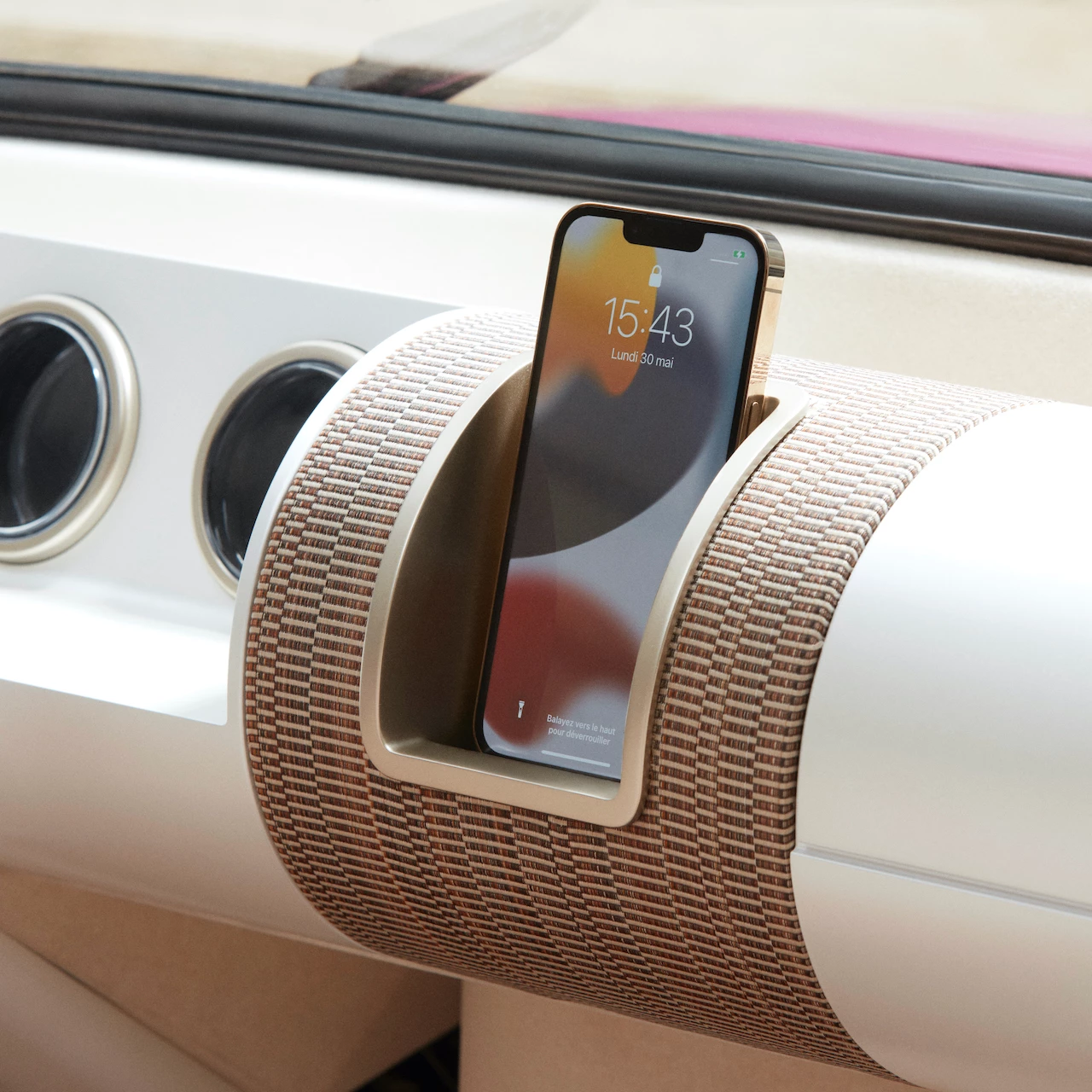 The driver's smartphone sits in a dashboard receptacle