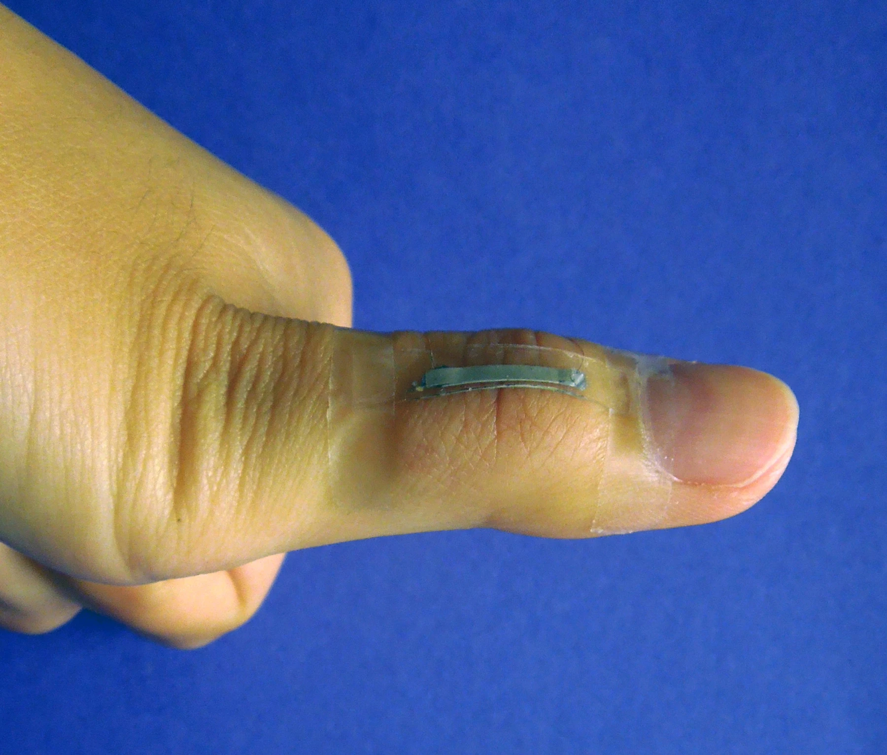 A silver nanowire-based sensor mounted onto a thumb joint to monitor the skin strain associated with thumb flexing (Photo: Shanshan Yao)