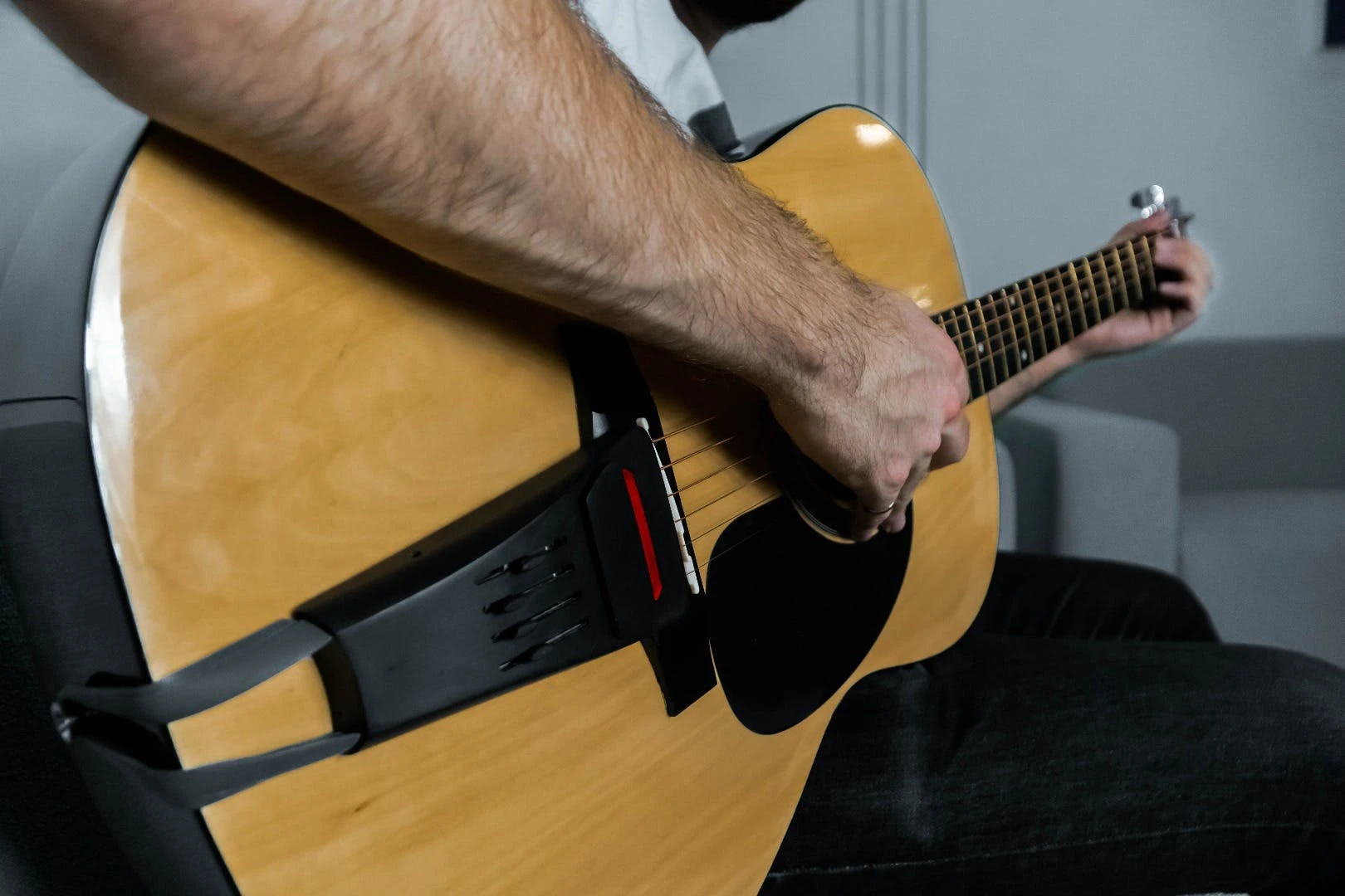 The Pulse is held in place by gripping the string pegs at the bridge and wrapping a band around the strap nut