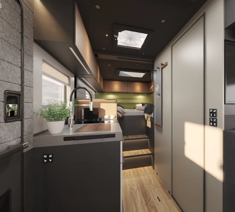 Looking back toward the bedroom past the kitchen and bathroom; the retracted auto-lift kitchen shelf and open bedroom door create a more spacious interior feel
