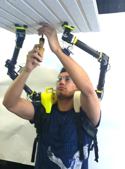Researcher demonstrates the operation of the robot arms when installing ceiling panels in an airplane
