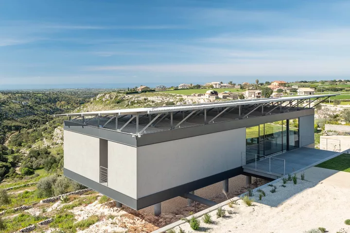 Italian architectural firm Giuseppe Gurrieri Studio has recently finished a stunning single-family home that balances on 12 slim pillars