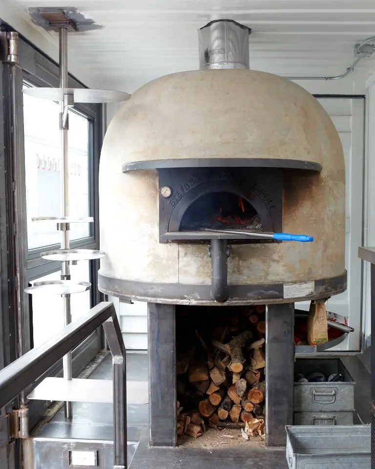 The smoldering temperatures reached inside a traditional wood-fired oven cooks the perfect pizza base in a matter of minutes