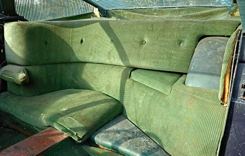 An unusual rear seating arrangement where there is a sole one-person, sideways-facing seat