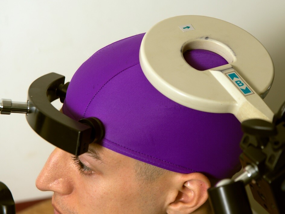 A transcranial magnetic stimulation coil located above the part of the brain that controls hand movements (Photo: Mary Levin, University of Washington)