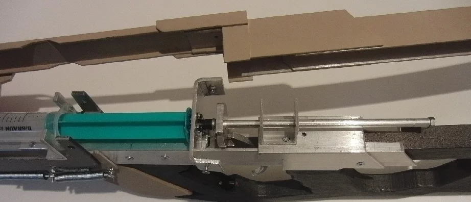 A spring-loaded steel rod (right) is used to force the piston into the syringe, hard and fast