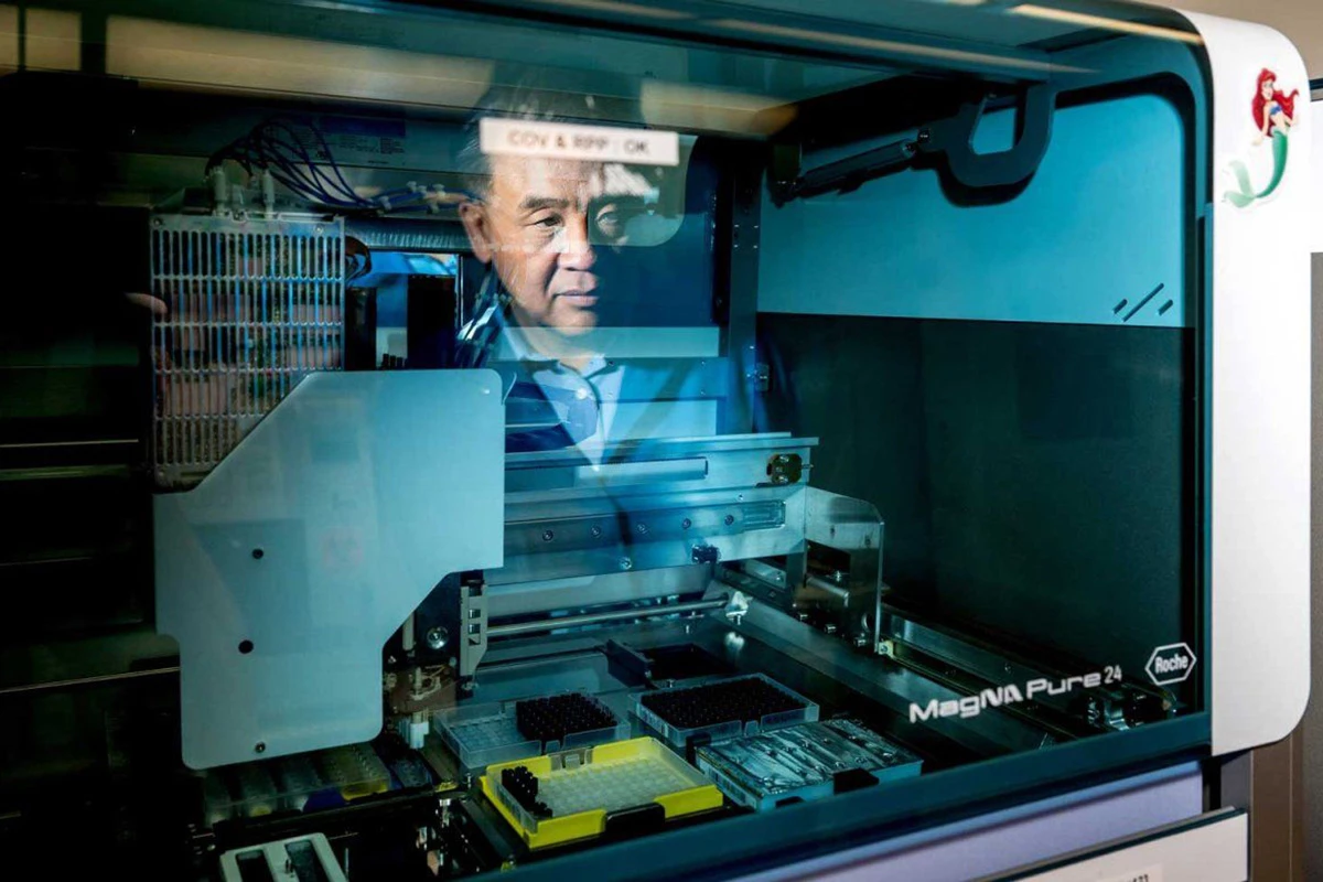 UCSF microbiologist Charles Chiu watches as a robot extracts DNA from a sample