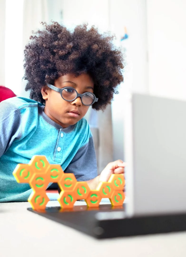 Plugo Link involves stacking magnetic hexagonal blocks to build structures and solve puzzles, learning logical and spatial reasoning along the way