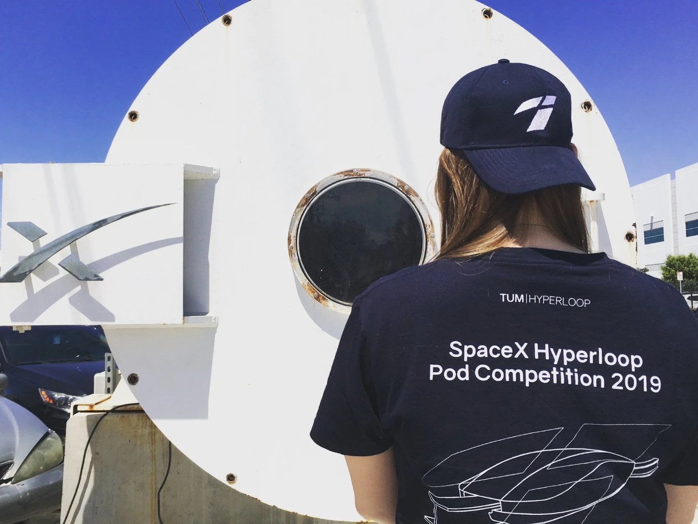 A TUM team member peers inside the test tube at SpaceX headquarters