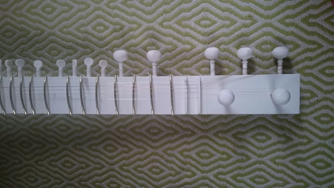 19 printed tuning pegs (or kunti) are placed at appropriate points along the head and neck