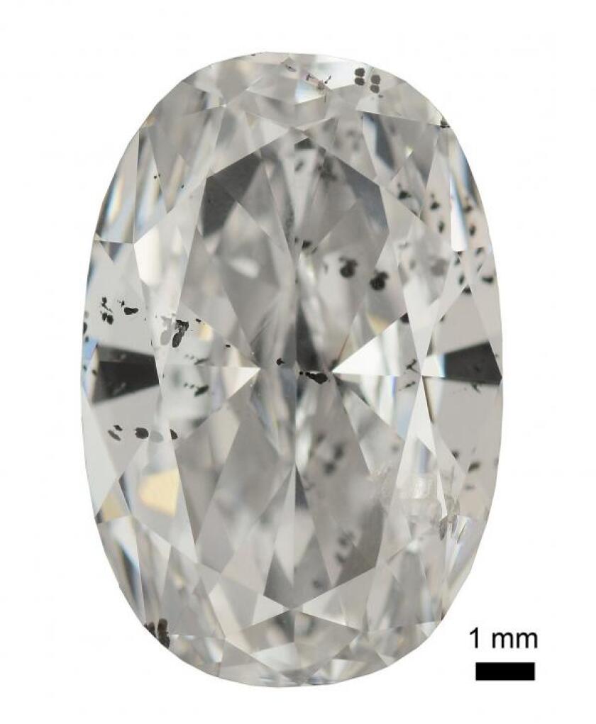 A cut and polished diamond with metallic inclusions – the most obvious group of inclusions looks like black spots on the left side, middle.