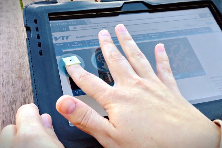 This person uses a fingernail-shaped chip to transfer data between a tablet and a smartphone with just a touch.