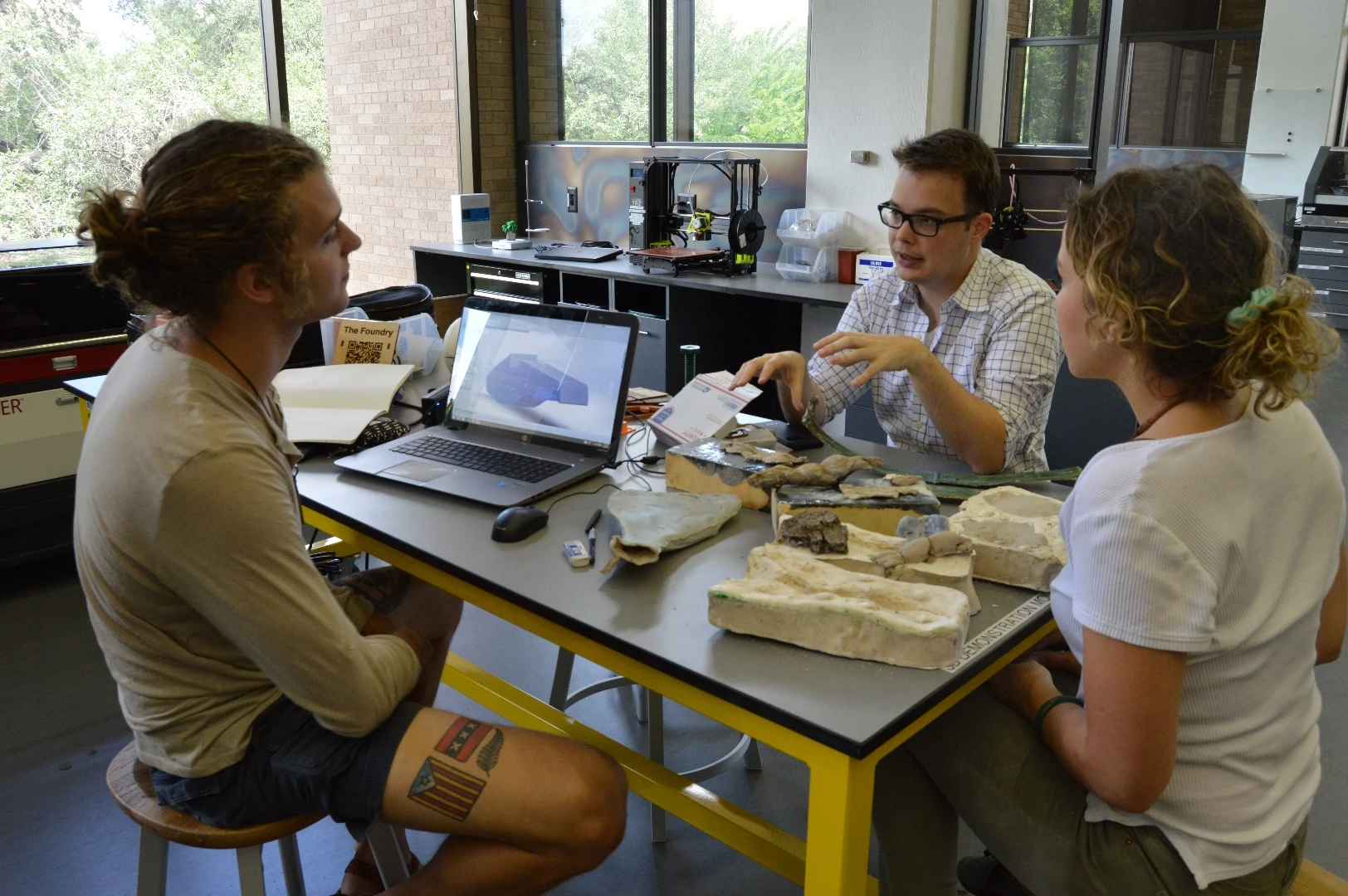 Daniel Goodwin (left), Sean Riley (center) and Rebecca Milton (right) discuss the design of the 3D-printed, 6-string violin project