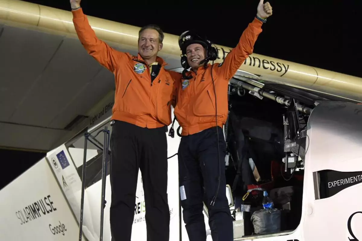 Andre Borschberg (L) and Bertrand Piccard celebrate after Solar Impulse 2 touches down in Abu Dhabi