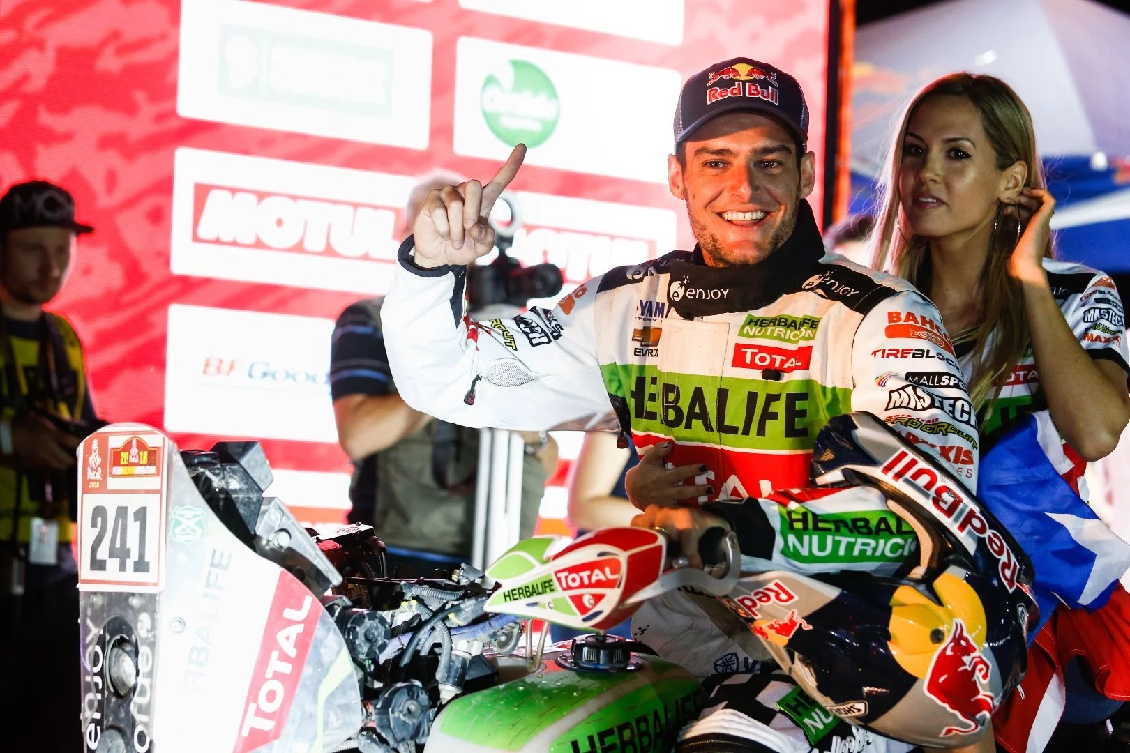 Chile's Ignacio Casale celebrates winning the quad bike division for Yamaha, with a slightly worried new friend riding pillion