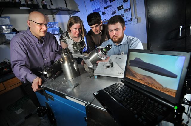 Ryan Starkey (left) with three of his team members, and some L-FX00 engine nozzle models (Photo: Glenn Asakawa/University of Colorado)