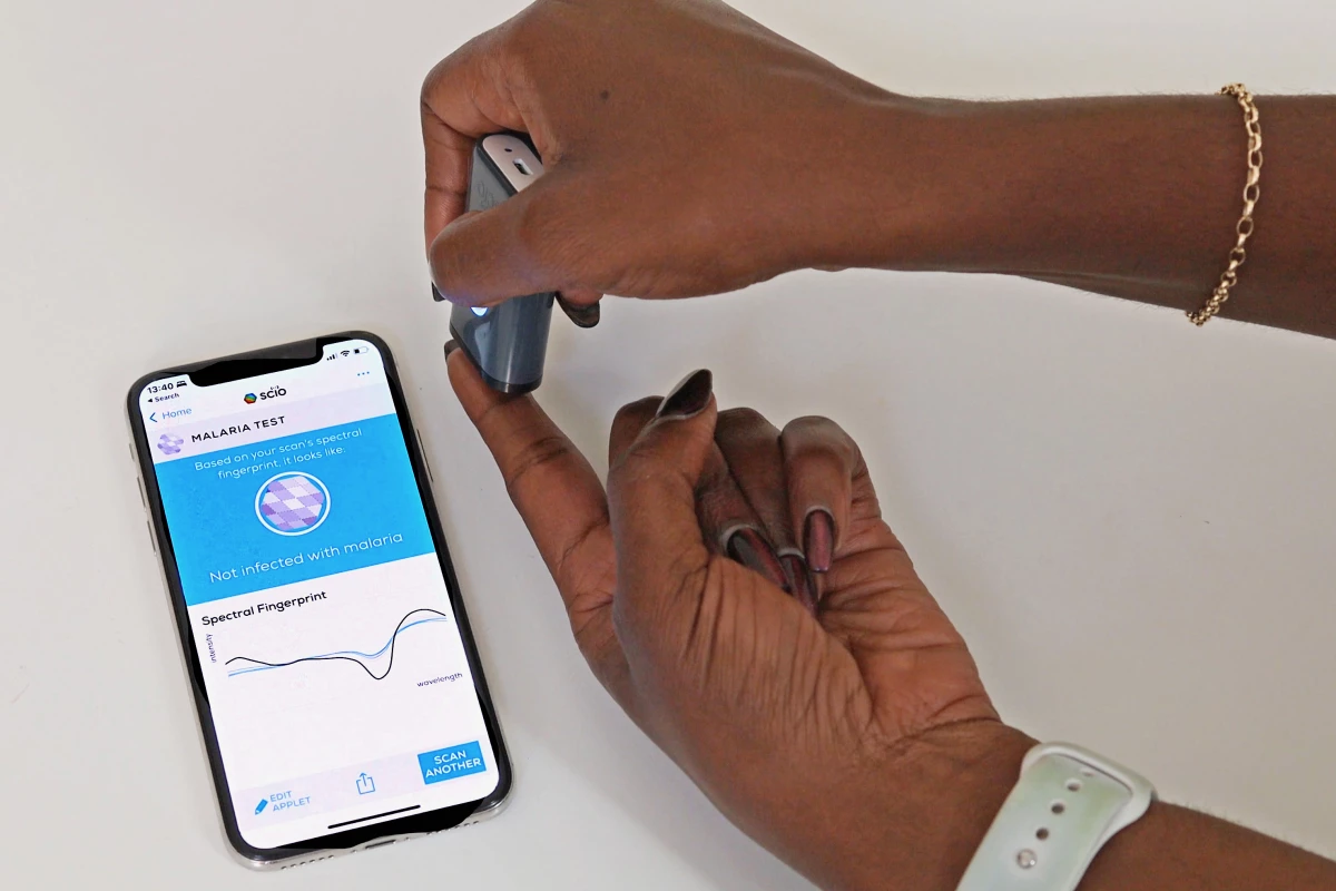 The hand-held spectrometer shines a beam of infrared light into the patient's earlobe or fingertip