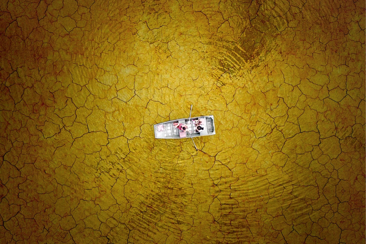 Some clever editing makes it look like this family is boating on a lake of cracking mud