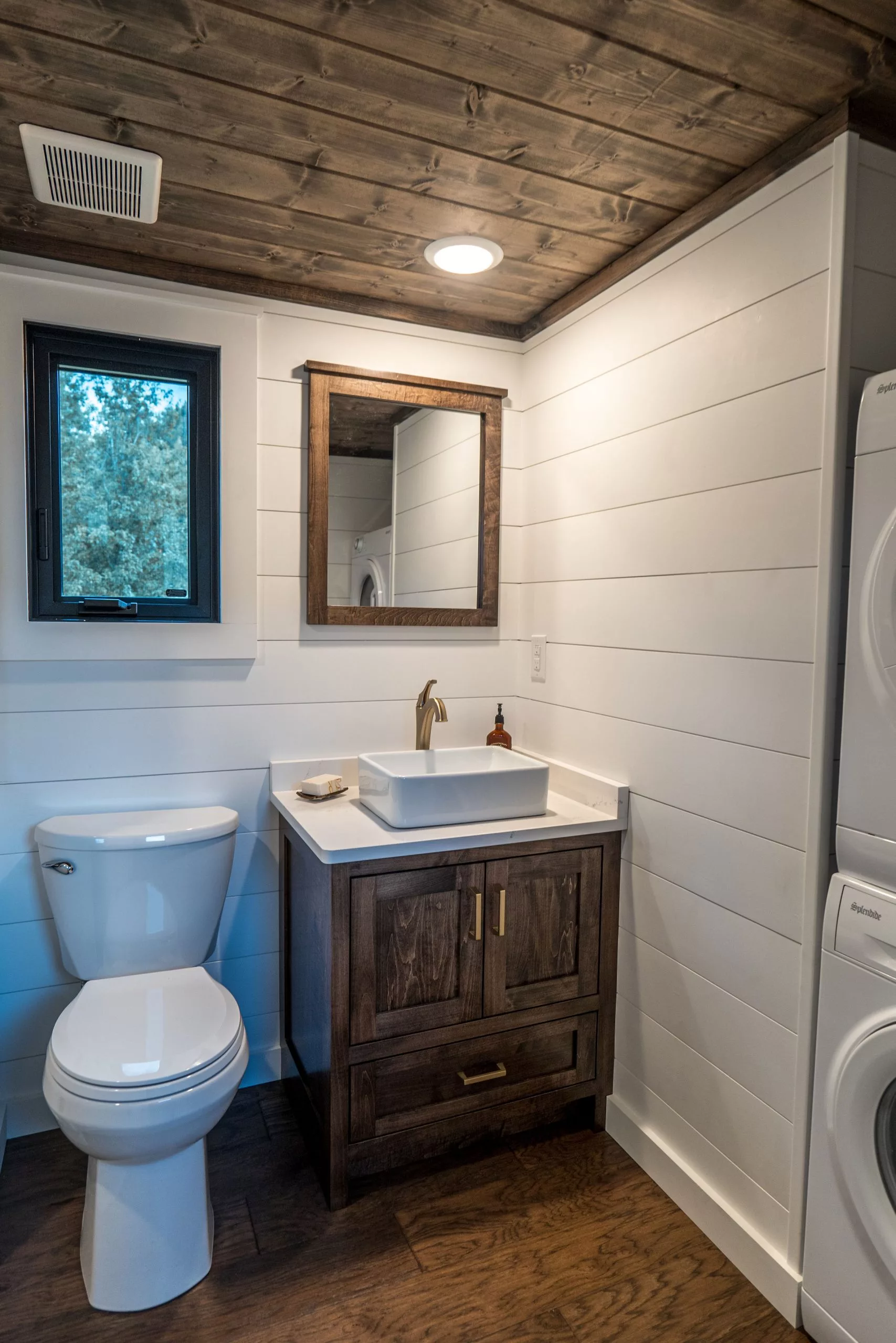 The Big Sky's bathroom includes a vanity sink, shower, flushing toilet, and a stacked washer and dryer