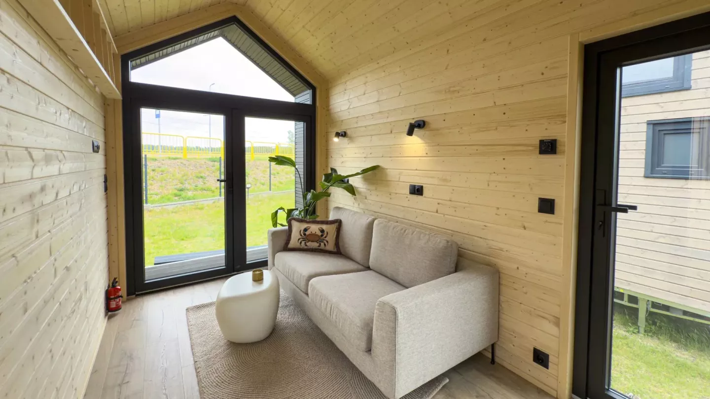 The lounge space in this promo shot has been furnished with a double sofa and small coffee table