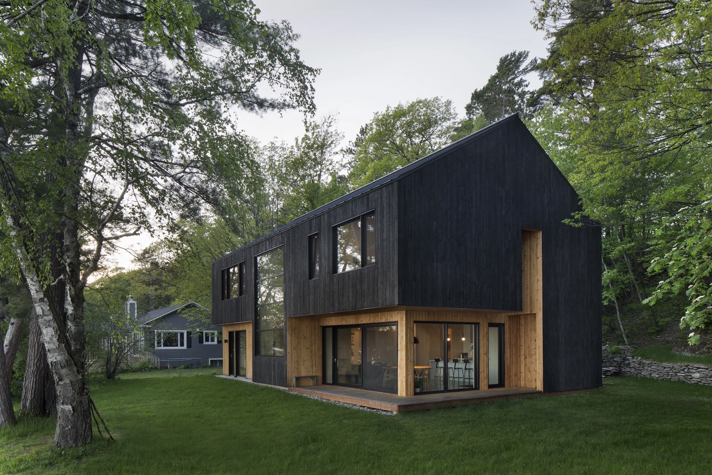 The Lakeside Cabin's exterior is finished in a local larch wood that has been charred using the Japanese Shou Sugi Ban method, lending it a distinctive appearance