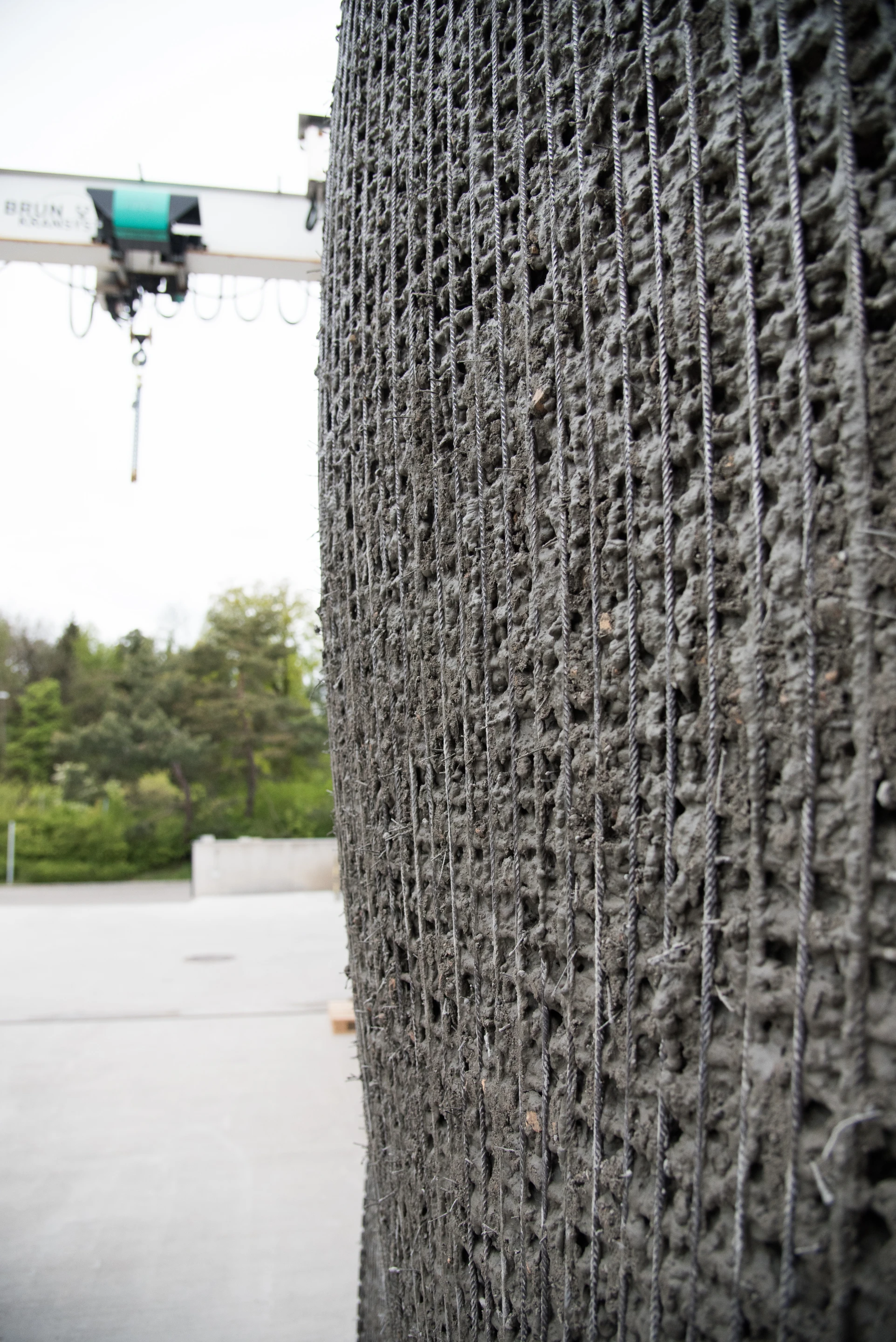 The mesh wall structure is built by a fabrication robot and filled with a special mix of concrete designed not to leak out of the frame