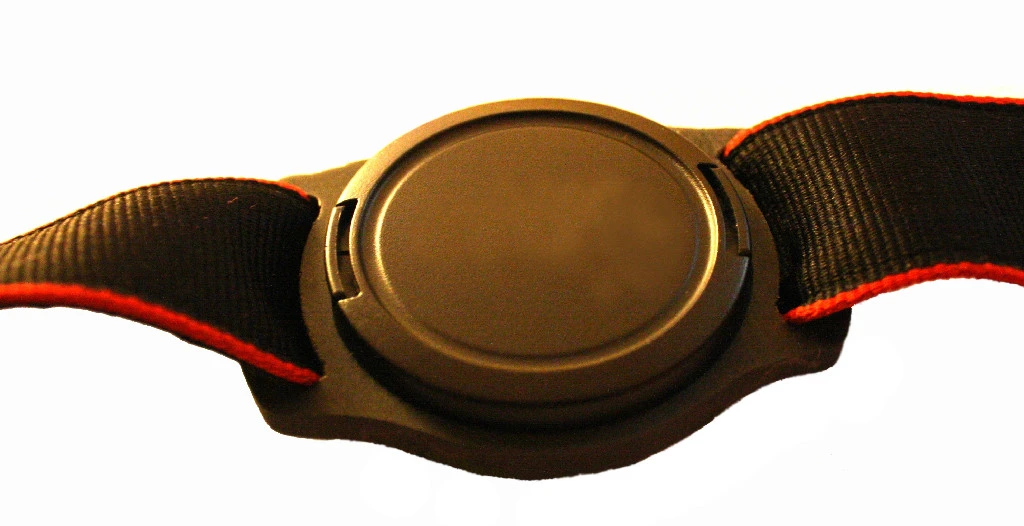 The camera strap slots through the buckle holes on either side of the circular recess of the holder