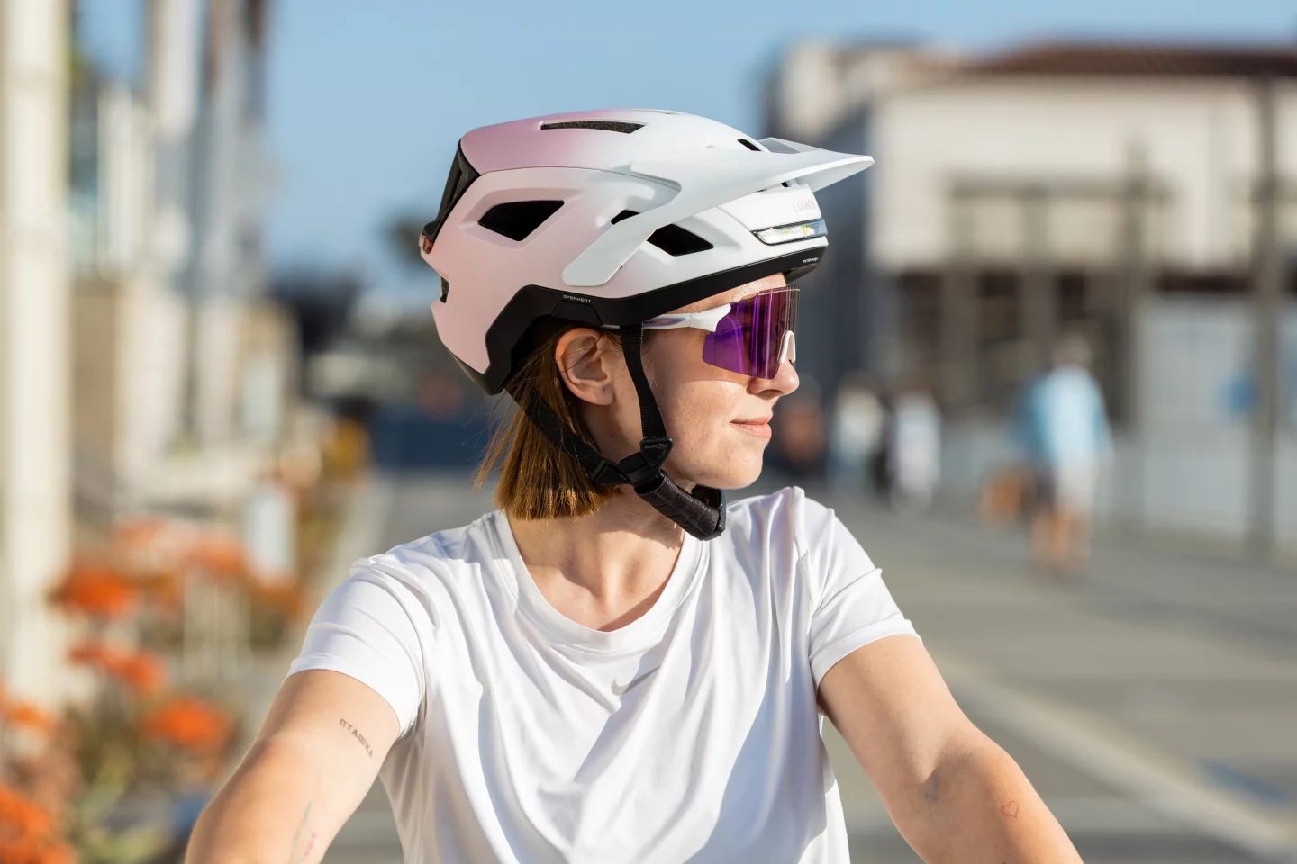 The helmet is available in a choice of four colors: black, white, pink-white gradient, and orange-yellow gradient