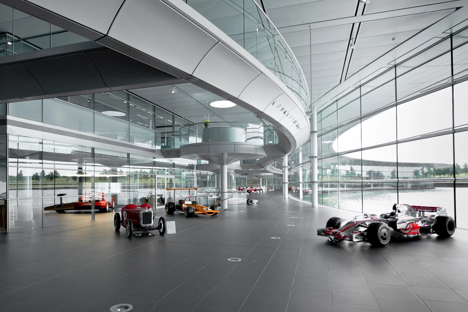 A veritable cornucopia of classic race cars sits on the floor in the McLaren Technology Center